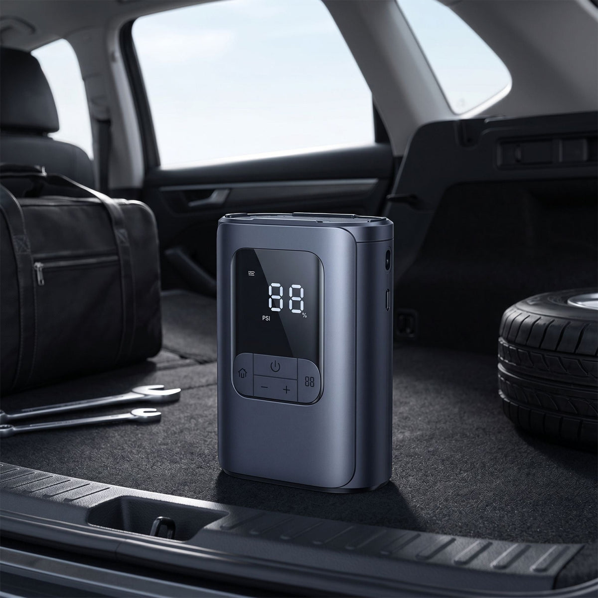 Unbranded compact tire inflator standing in a vehicle interior, with natural light and car environment background.