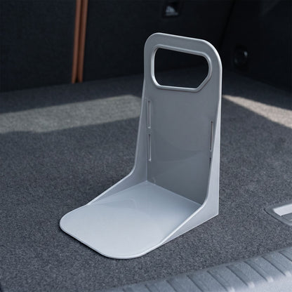 Close-up of a small plastic trunk organizer demonstrating durable material and anti-slip bottom in a garage setting.