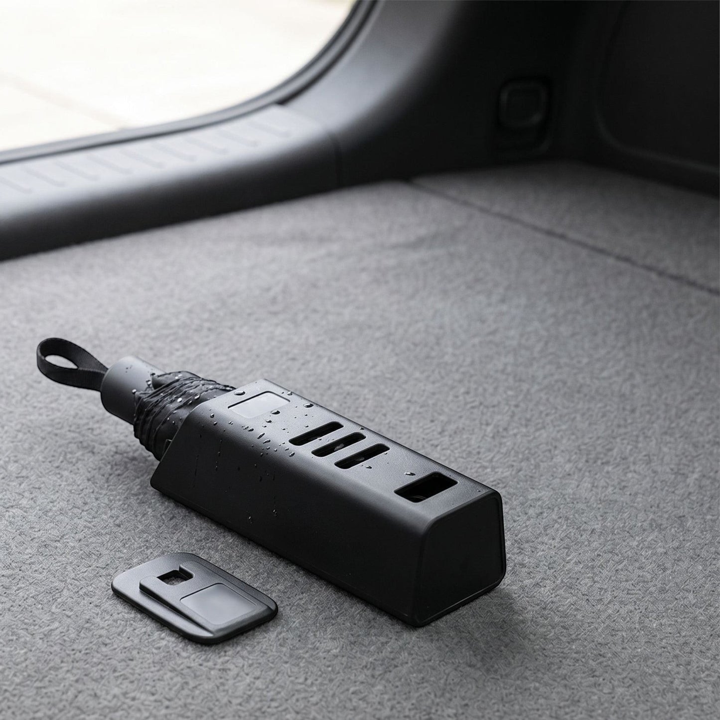 Close-up of waterproof vehicle umbrella holder on trunk floor with a wet umbrella, highlighting material and size.