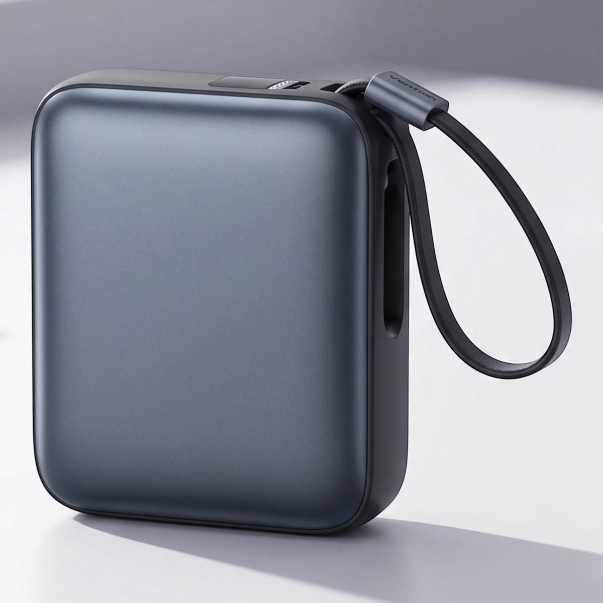 Close-up of a generic mini power bank with digital display and USB-C ports on a neutral surface under natural light.