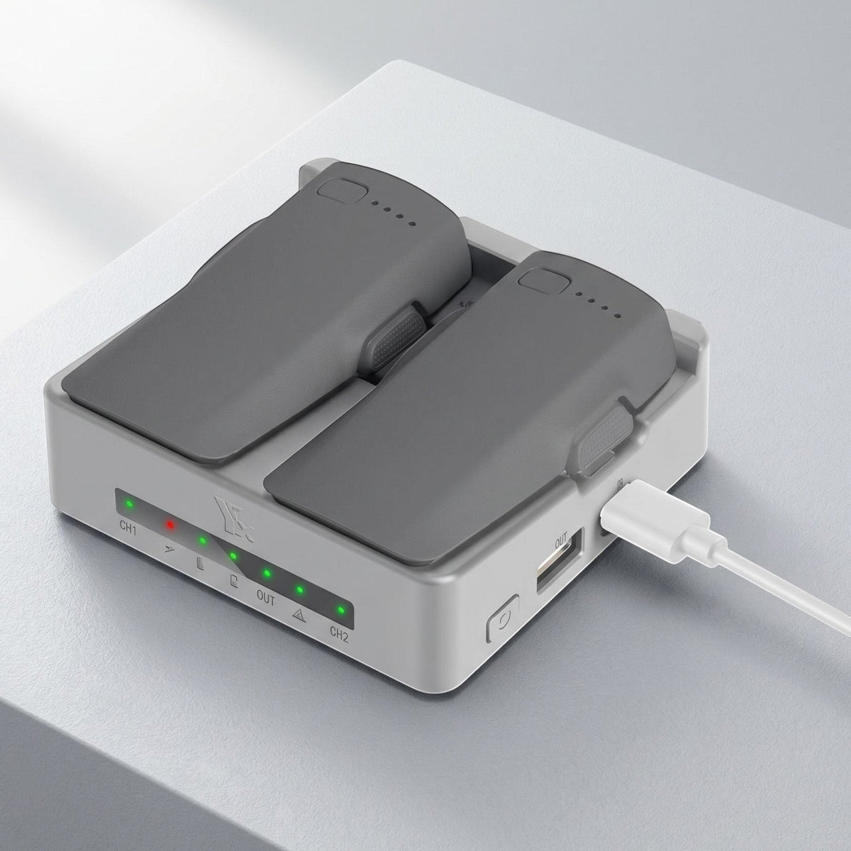 Small drone battery charging hub with dual slots and USB port on a sleek studio surface, showcasing its compact design and features.