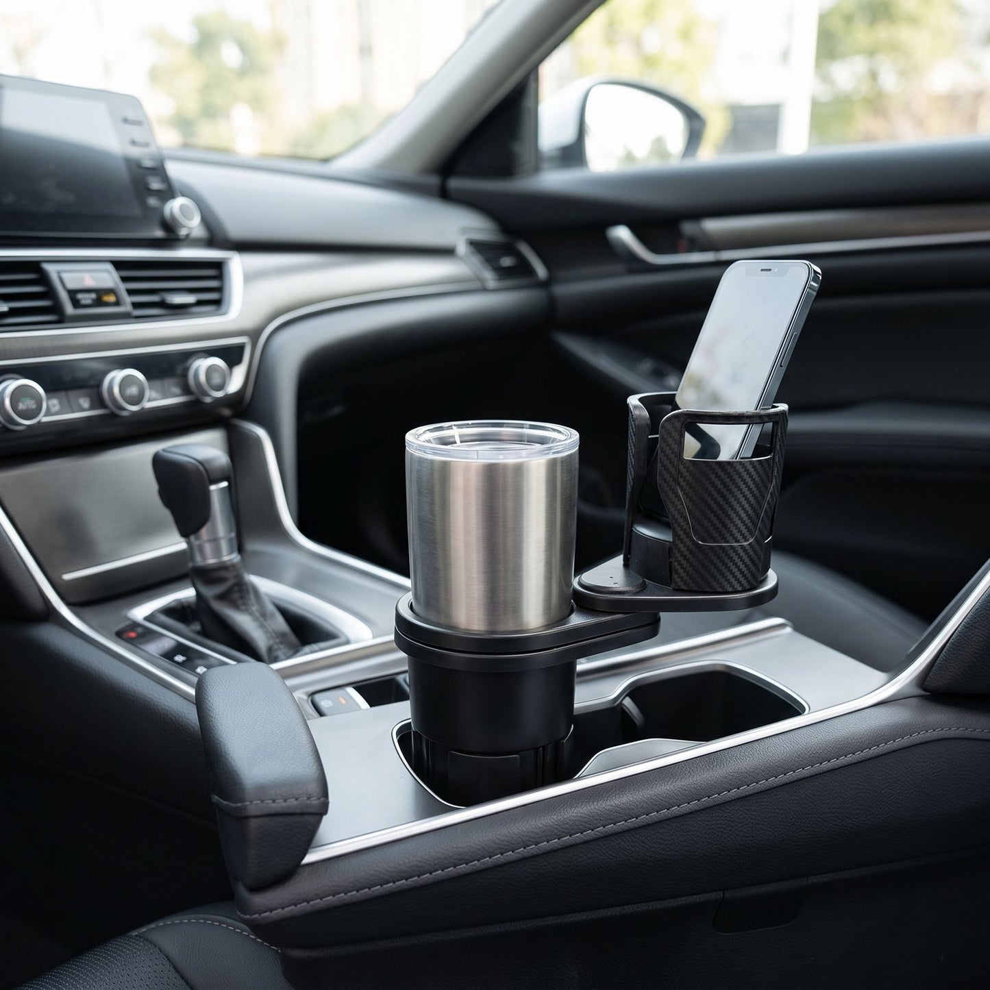 Wide shot of a sleek car interior featuring a compact dual cup holder on the center console in natural lighting.
