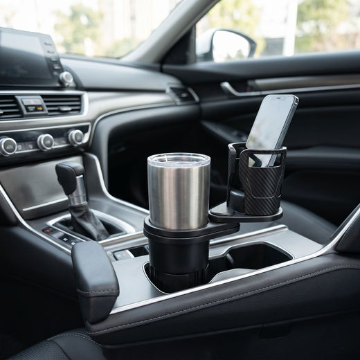 Wide shot of a sleek car interior featuring a compact dual cup holder on the center console in natural lighting.