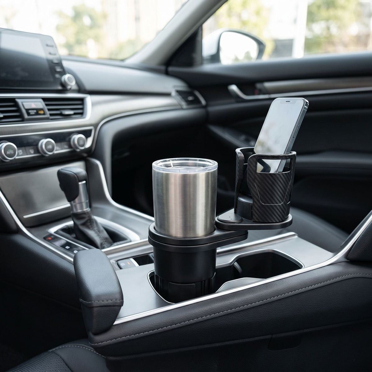 Wide shot of a sleek car interior featuring a compact dual cup holder on the center console in natural lighting.
