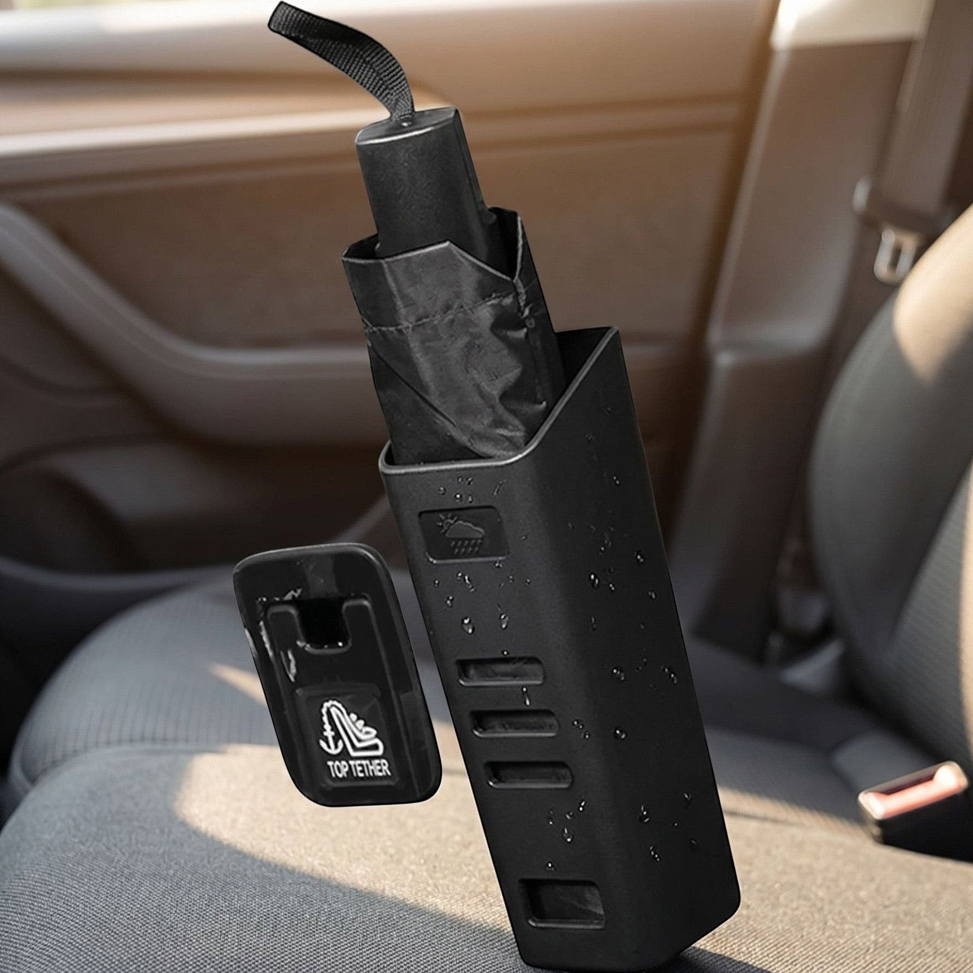 Small unbranded car umbrella holder positioned on car seat or floor, holding a wet umbrella in a realistic vehicle interior scene.