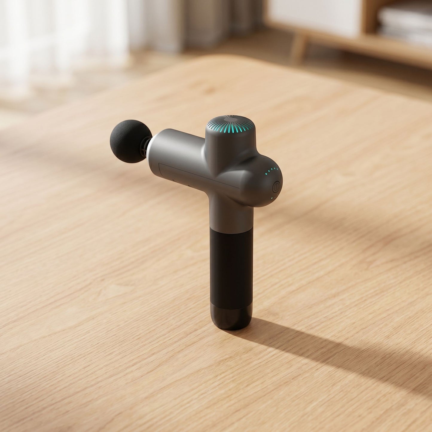 Unbranded electric massage gun on wooden surface in bright modern home, showcasing its sleek shape, ports, and buttons.