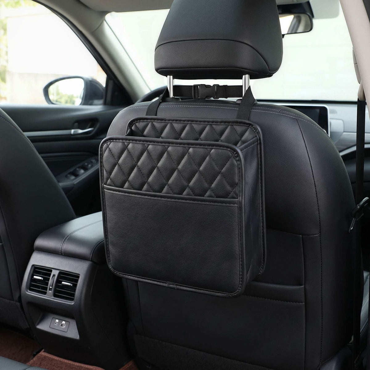 Full view of a small car seat organizer hanging from the front seat in a well-lit vehicle interior, emphasizing its practical and straightforward design.