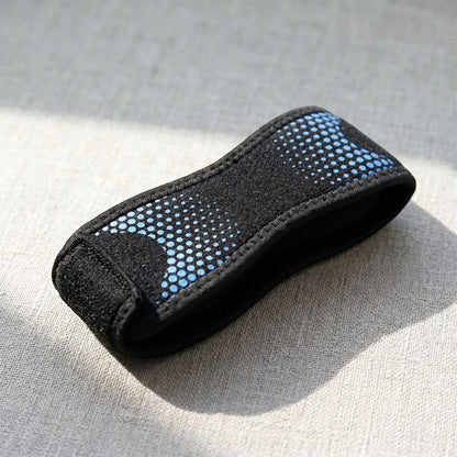 Close-up of knee strap placed on textured surface highlighting adjustable strap and knit fabric details.