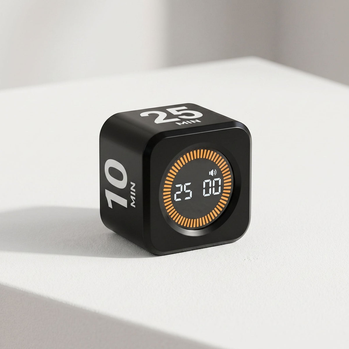 Diminutive digital timer with LCD display on white surface in professional studio, emphasizing sleek surface and controls.