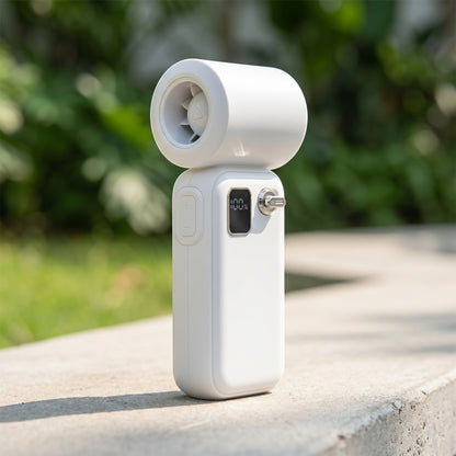 Outdoor scene with a white turbo fan on a concrete surface, sunlight highlighting its metallic and plastic finishes.