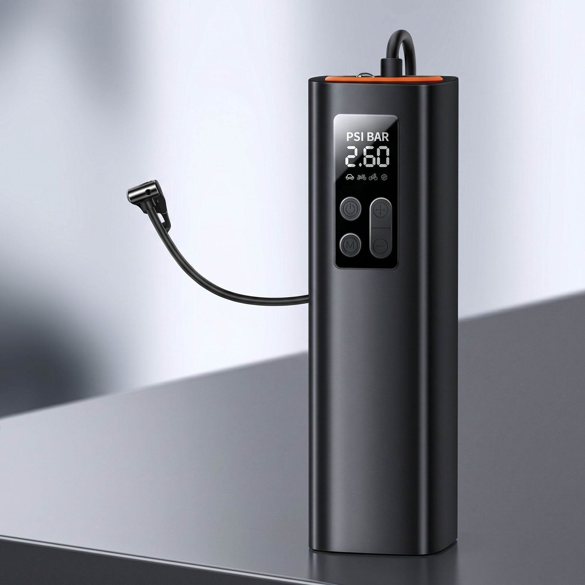 Close-up of a small tire inflator on a reflective surface, highlighting its ports, pressure display, and realistic plastic texture.