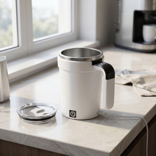 Close-up of a self-stirring coffee cup showing stainless steel interior and leak-resistant lid on a modern kitchen counter.