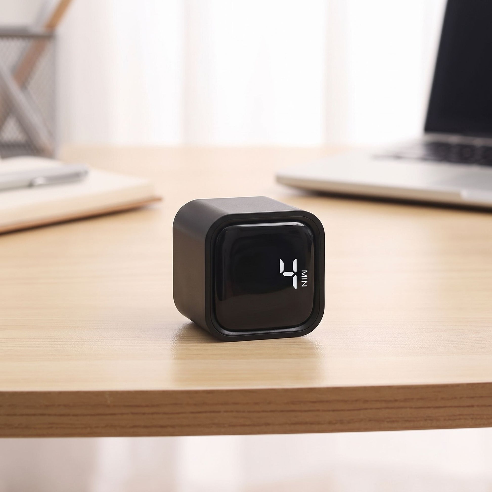 Side view of a digital timer set for 4 hours on an office desk, with natural daylight and soft shadows highlighting its minimalist design.