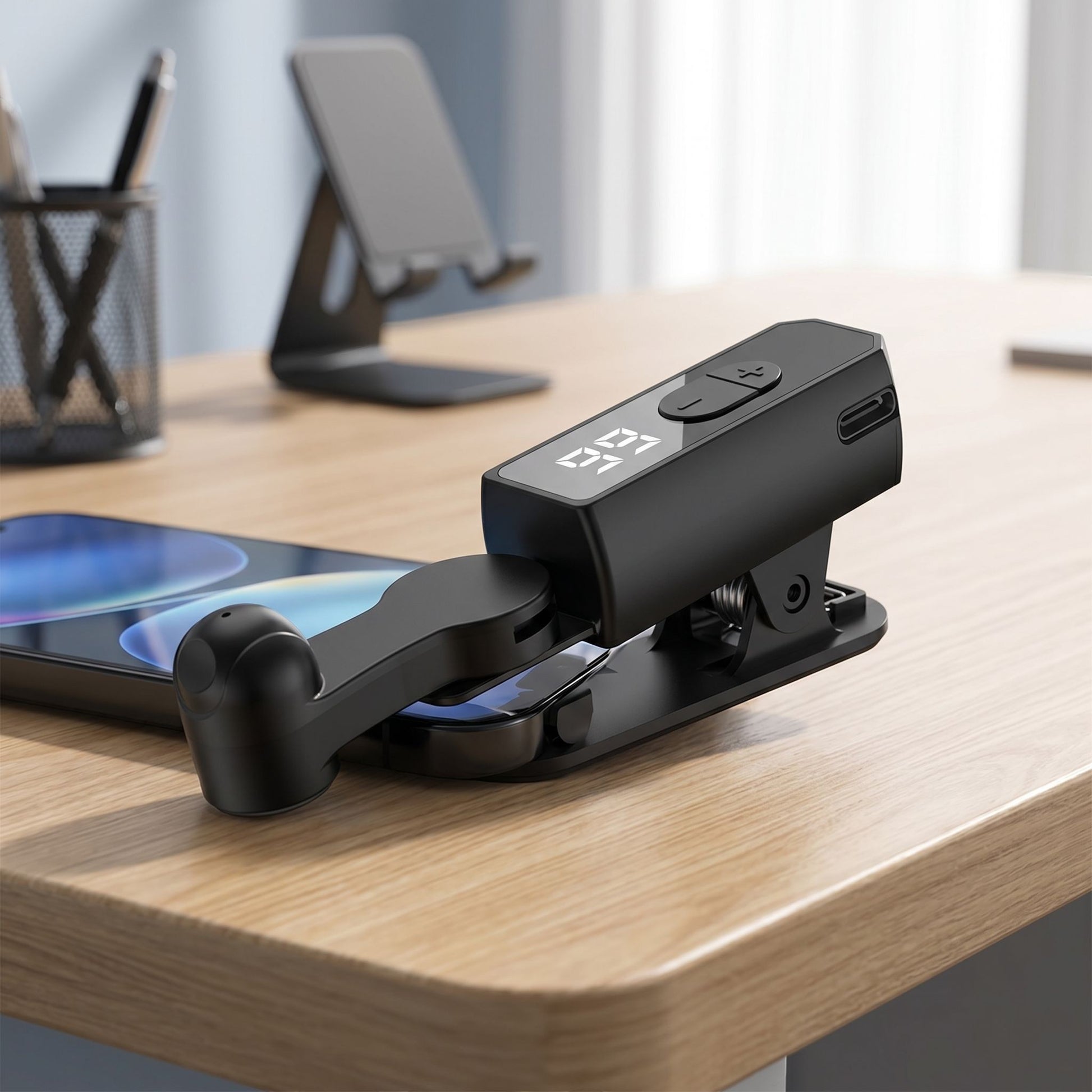 Side perspective of auto screen clicker clipped onto a smartphone on a contemporary workspace, emphasizing portability and design.