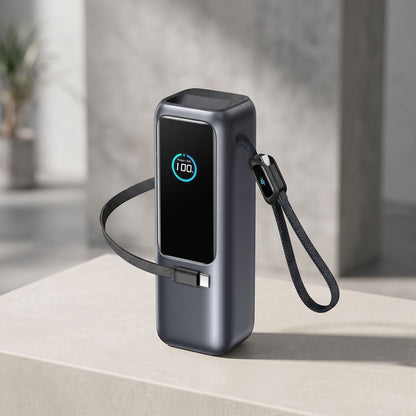 Generic 25000mAh power bank with integrated cables and digital display, positioned on a light surface in a modern studio setting.