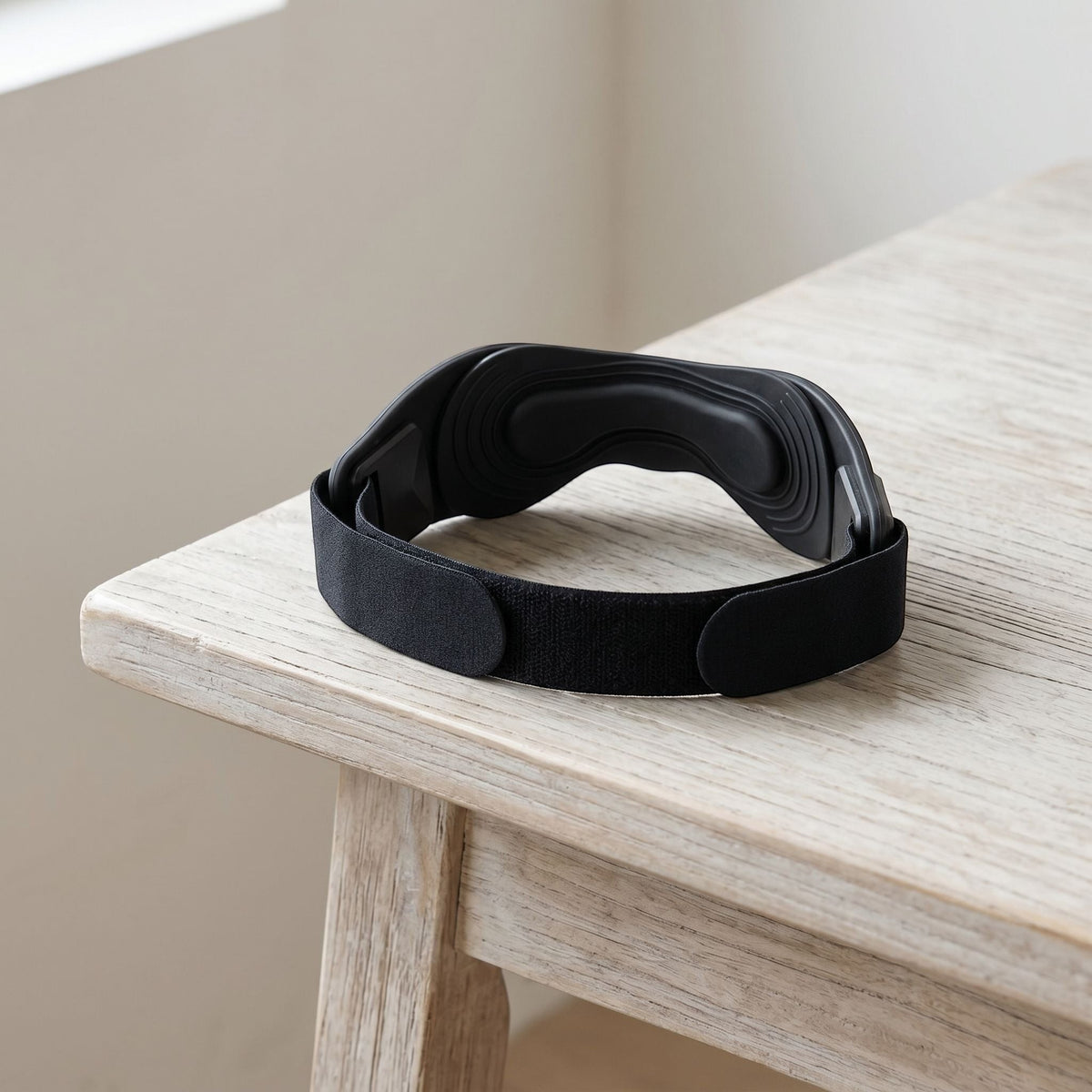 zero2cart black adjustable patellar tendon support strap with a contoured silicone pad on a wooden table