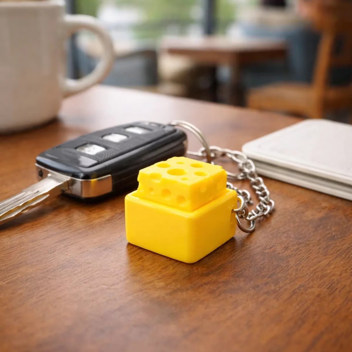 zero2cart yellow cheese-shaped fidget clicker keychain on a wooden table next to car keys