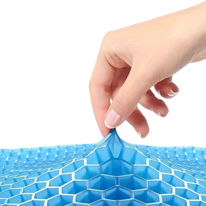 A hand pulling on a blue zero2cart gel seat cushion with a flexible honeycomb structure for cooling support.