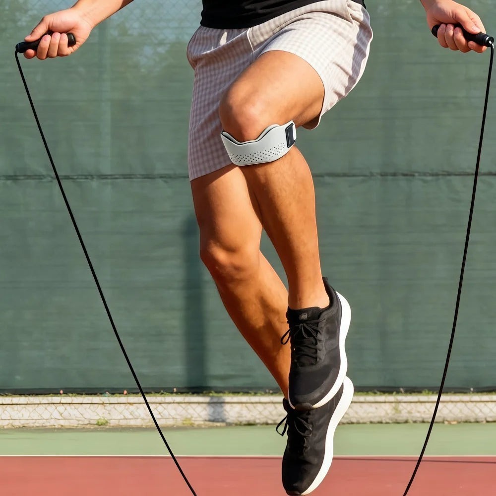 zero2cart gray adjustable patellar tendon support strap worn by a man jumping rope on an outdoor sports court
