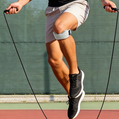 zero2cart gray adjustable patellar tendon support strap worn by a man jumping rope on an outdoor sports court