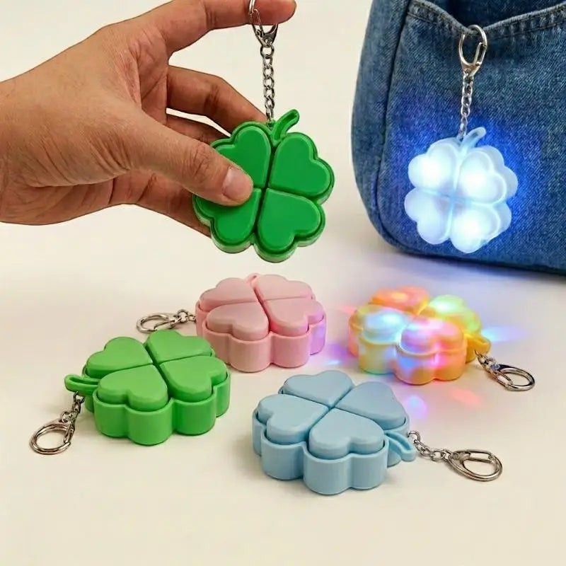 zero2cart light-up four-leaf clover pop-it fidget keychains in green, pink, blue, and yellow with LED glow effect