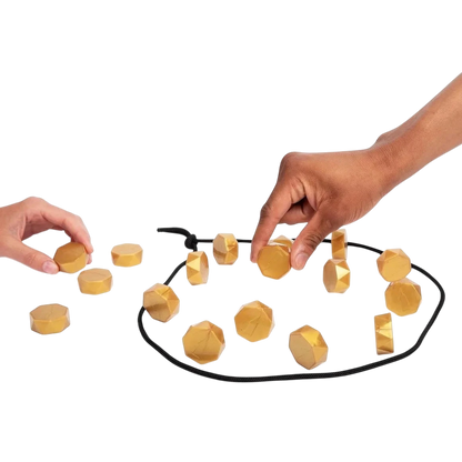 zero2cart magnetic strategy game with gold-colored faceted stones being placed by two players on a black rope board