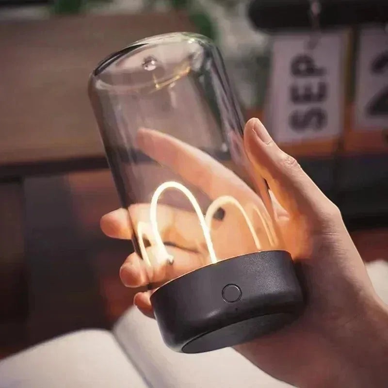 zero2cart portable rechargeable night light with a clear glass cylinder and warm glowing filament in a hand