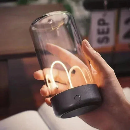 zero2cart portable rechargeable night light with a clear glass cylinder and warm glowing filament in a hand