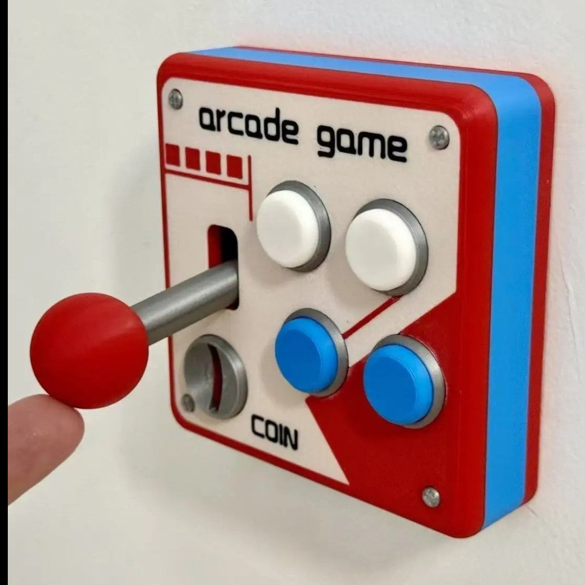 zero2cart retro arcade style light switch cover with a red joystick and buttons on a white wall